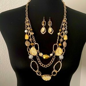 3 tier gold necklace with matching earrings.